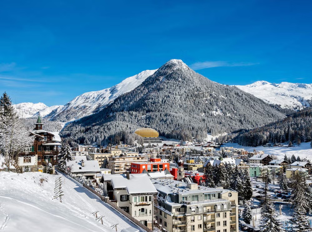 Snow-covered town of Davos, Switzerland in winter with sunlit alpine peaks